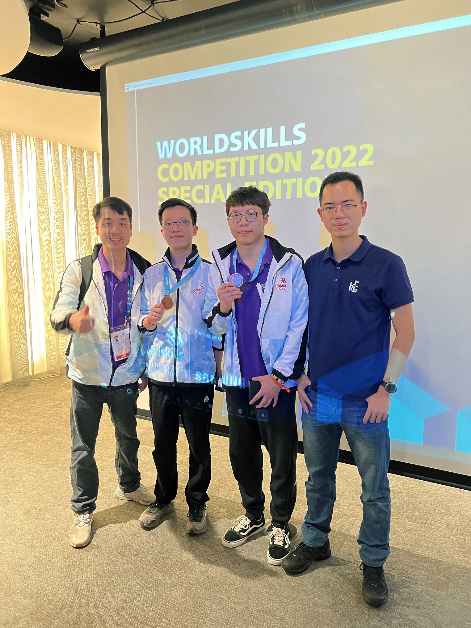 IVE机械工程学高级文凭毕业生吕嘉杰(右二)及电机工程高级文凭毕业生郑鹤明(左二)为「机械人」项目香港代表,成功获得世界技能大赛特别赛优异奬章,二人与项目专家丶IVE(青衣)工程系署理高级讲师卢永权(左一)及业界代表合照